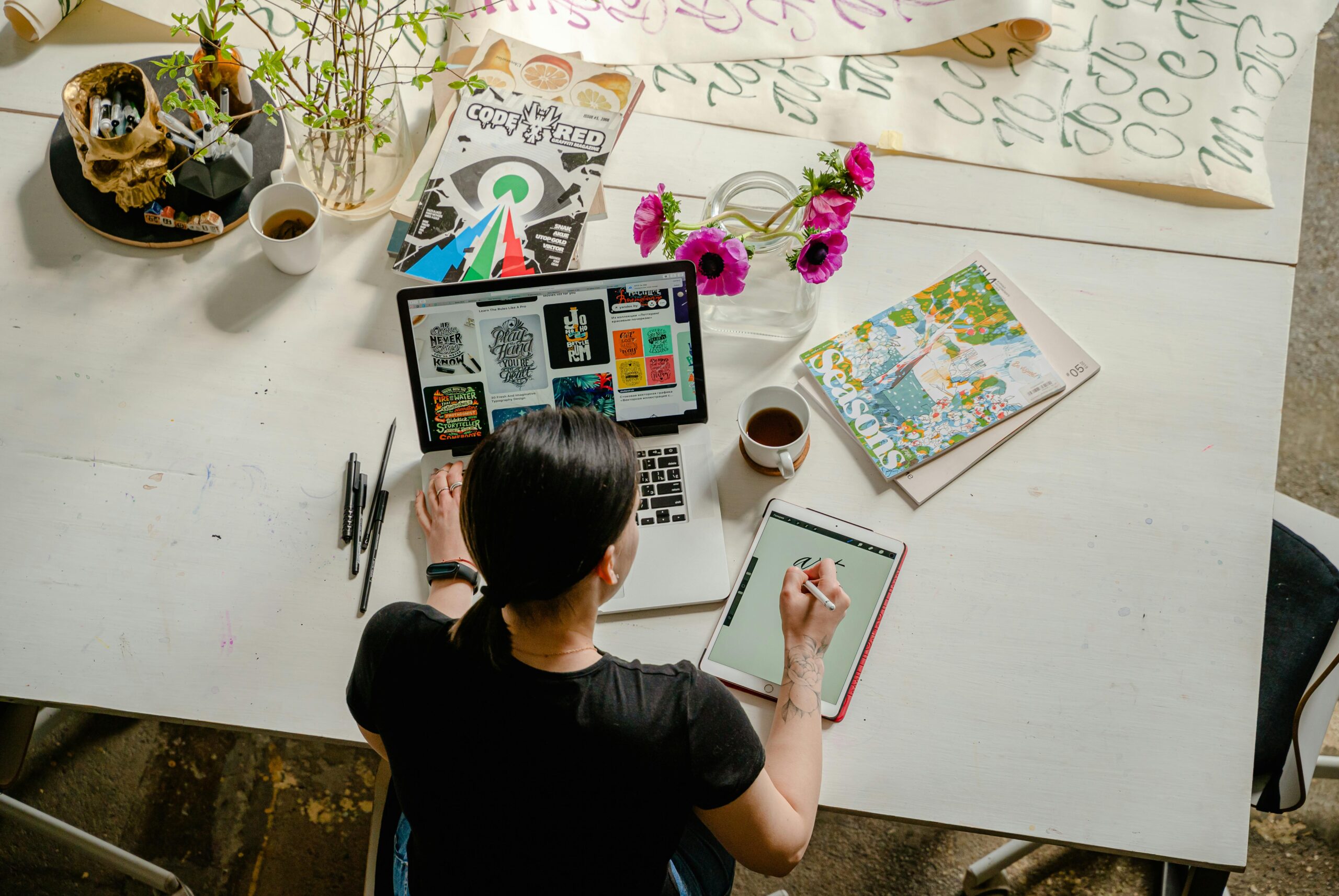 Person working alone on her sole proprietorship, surrounded by books, papers and computer screen