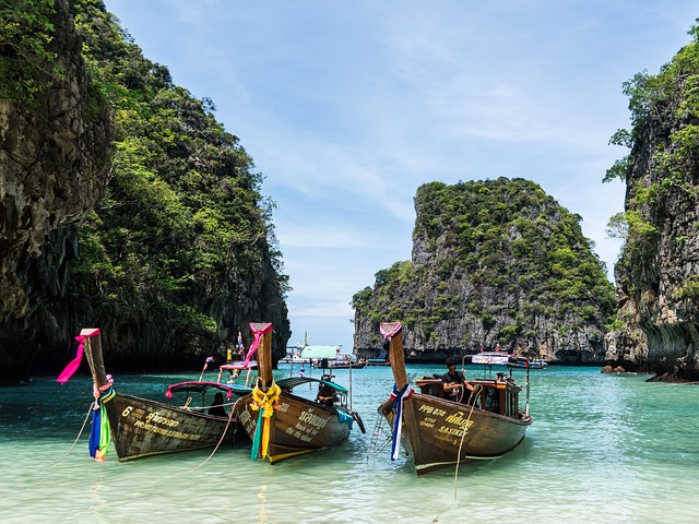 a photo of three boats sitting on a calm water in between stacks