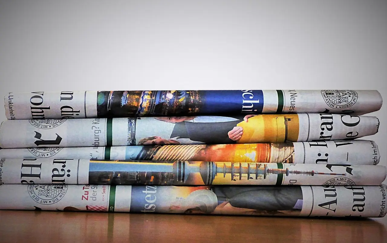 daily news summary in newspaper stacked on table